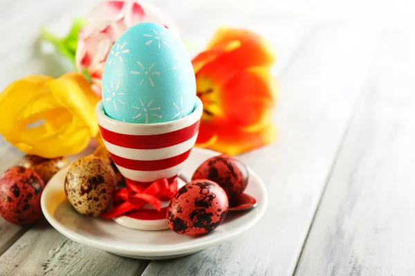 Paskalya yortusu yumurta tutucu ve Lale çiçek ahşap arka plan üzerinde — Stok fotoğraf