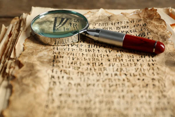 Grunge papers with hieroglyphics with magnifier close up — Stock Photo, Image