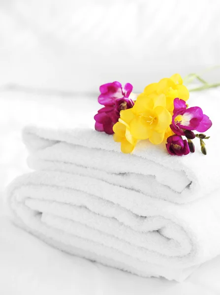 Colorful beautiful freesias on fresh towels in hotel, close up — Stock Photo, Image