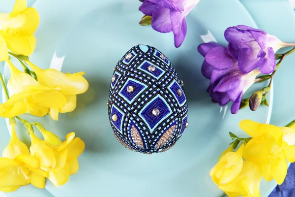 Пасхальные яйца с цветами на тарелке — стоковое фото