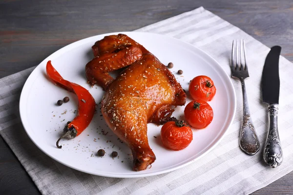 Smoked chicken leg  with vegetables on plate on table close up — Stock Photo, Image