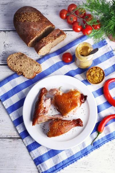 Smoked chicken with vegetables on plate on table close up — Stock Photo, Image