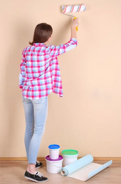 Bella donna dipinge parete in camera — Foto Stock