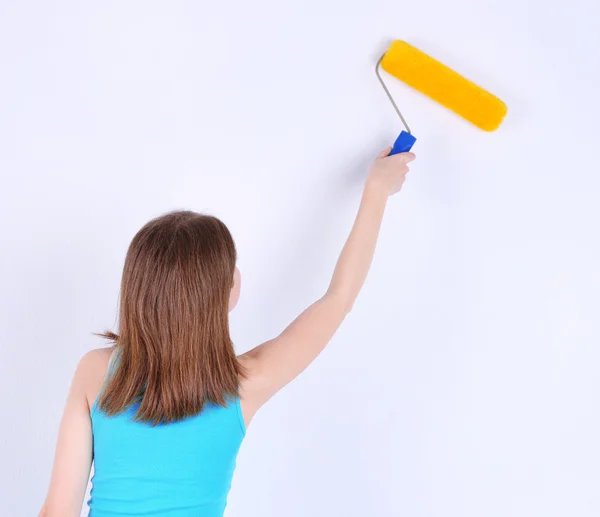 Schönes Mädchen bemalt Wand im Zimmer — Stockfoto