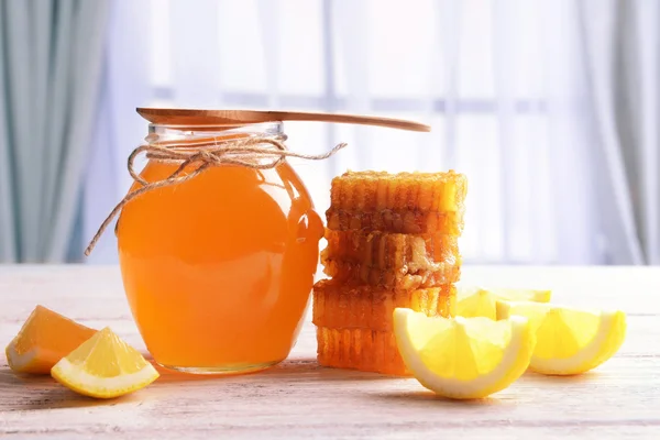 Läcker honung med citron på bordet på ljus bakgrund — Stockfoto