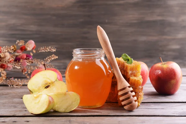 Delicious medu s jablky na tabulce na dřevěné pozadí — Stock fotografie