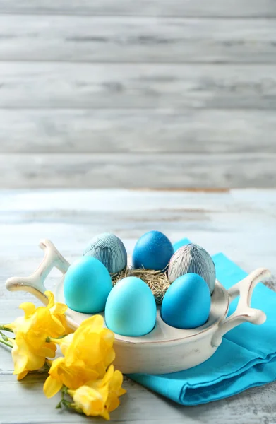 Composición de Pascua con huevos de colores en el soporte sobre fondo de mesa de madera —  Fotos de Stock