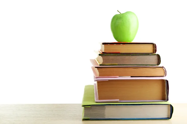 Libros y manzana en el escritorio, aislados en blanco — Foto de Stock