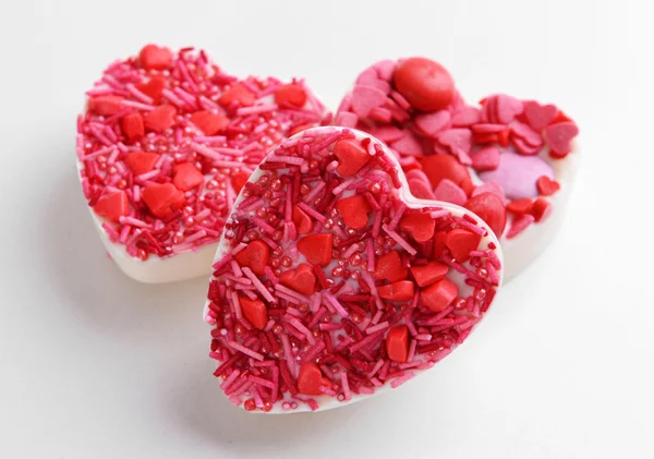 Deliciosos caramelos de chocolate en forma de corazón aislados en blanco —  Fotos de Stock