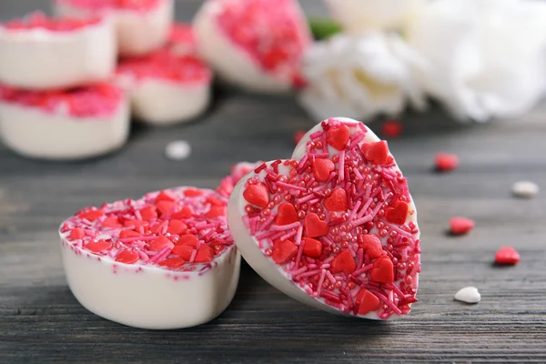 Вкусные шоколадные конфеты в форме сердца на столе крупным планом — стоковое фото