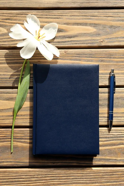 Cuaderno con pluma y tulipán blanco sobre fondo de madera —  Fotos de Stock