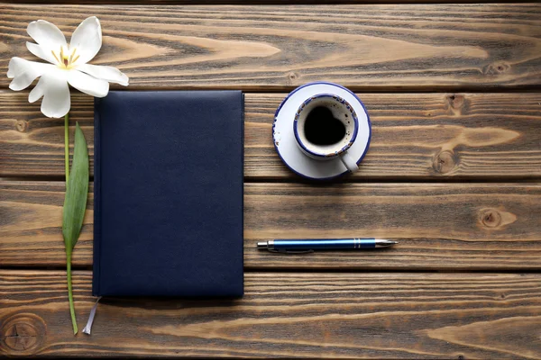 Anteckningsbok med kopp av kaffe och vita tulpaner på trä bakgrund — Stockfoto