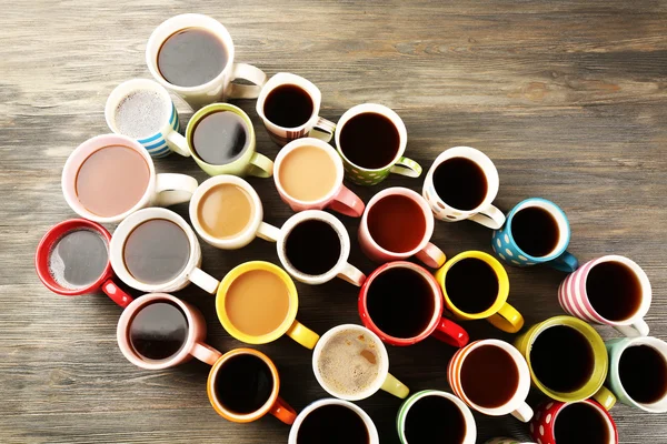 Muitas xícaras de café na mesa de madeira, vista superior — Fotografia de Stock
