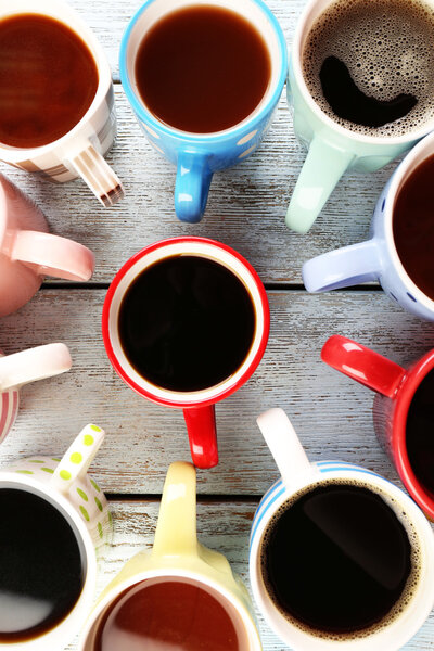 Many cups of coffee on wooden table, top view