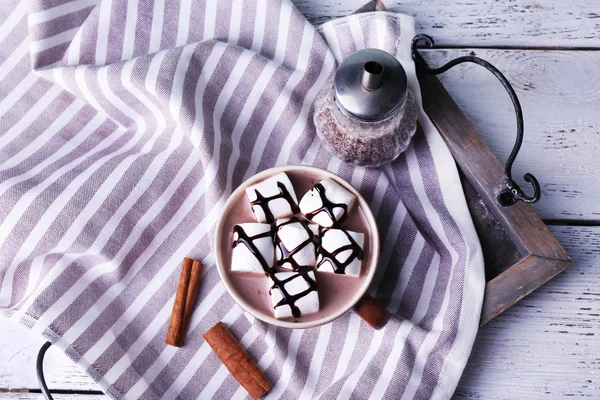 Cup of cocoa with marshmallows on tray and stripped napkin, closeup — Stock Photo, Image