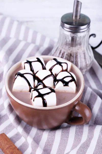 Чашка какао с зефиром на подносе и раздетая салфетка, крупным планом — стоковое фото