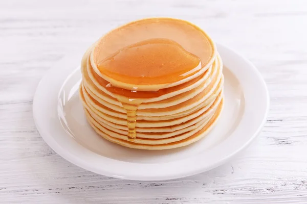 Läckra pannkakor med honung på tallriken på bordet närbild — Stockfoto