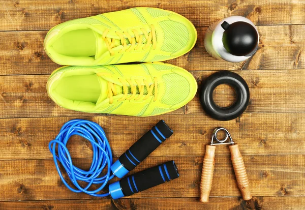 Schoenen en sport apparatuur op houten vloer, bovenaanzicht — Stockfoto