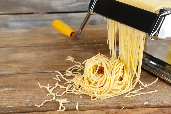 Att göra spån med pasta maskin på trä bakgrund — Stockfoto