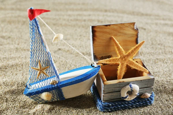 玩具船模型的木箱与海砂背景上的海星 — 图库照片