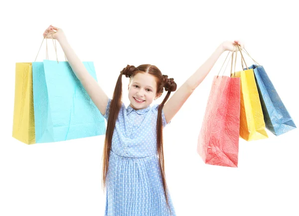Güzel küçük bir kız ile alışveriş torbaları, üzerinde beyaz izole — Stok fotoğraf