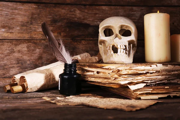 Bodegón con cráneo humano, libro retro y pluma sobre fondo de madera —  Fotos de Stock