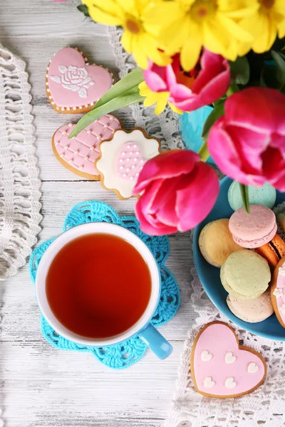 Состав весенних цветов, чая и печенья на столе крупным планом — стоковое фото
