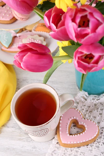 टेबलवर वसंत ऋतु फुले, चहा आणि कुकीजची रचना — स्टॉक फोटो, इमेज