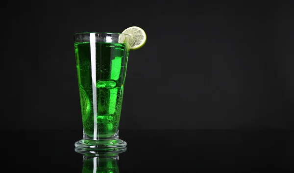Flaming green cocktail on dark background — Stock Photo, Image