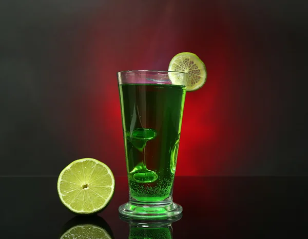 Flaming green cocktail on colorful background — Stock Photo, Image