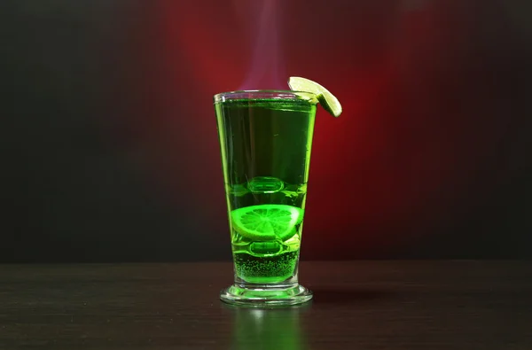 Cocktail verde fiammeggiante su sfondo colorato — Foto Stock