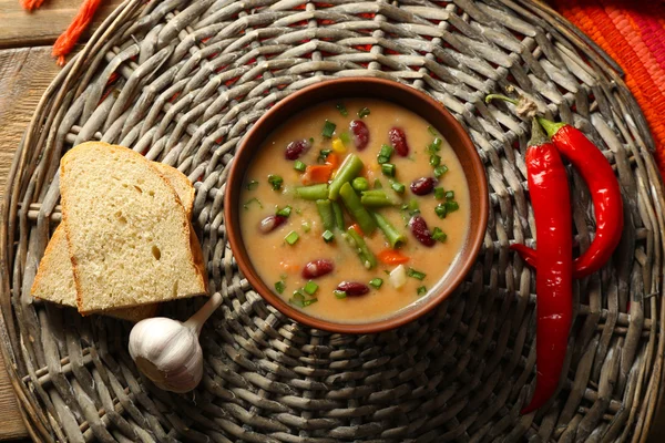 Sopa de feijão na tigela no fundo esteira de vime — Fotografia de Stock