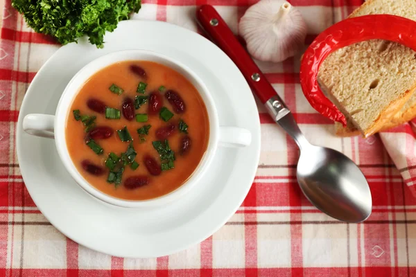 Bean soup in bowl with fresh sliced bread on napkin, on wooden table background — Stock Photo, Image