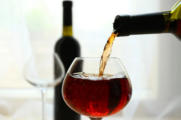 Vino tinto vertiendo en copa de vino, primer plano — Foto de Stock