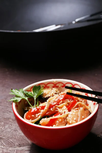 Macarrão chinês com legumes e frutos do mar em tigela e wok no fundo de madeira — Fotografia de Stock