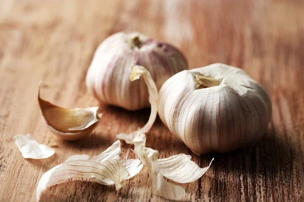 Raw garlic on wooden table — Stock Photo, Image