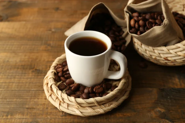 Kopje koffie met bonen op rustieke houten achtergrond — Stockfoto