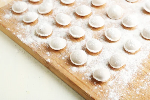 Raw dumplings on cutting board on table close-up — Stock Photo, Image