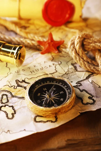 Bodegón marino con mapa del mundo y cuerda sobre fondo de mesa de madera — Foto de Stock