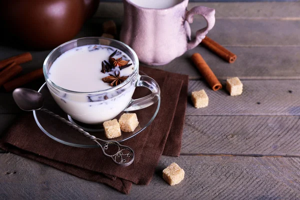 Teh hitam dengan susu di cangkir dan teko teh dengan lump gula pada warna kayu latar belakang papan — Stok Foto