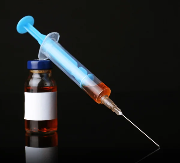 Ampule with syringe on black background — Stock Photo, Image