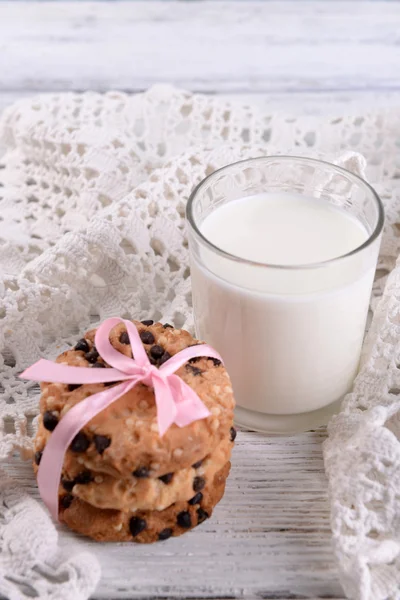 Tasty cookies and glass of milk on color wooden background — Stock Photo, Image