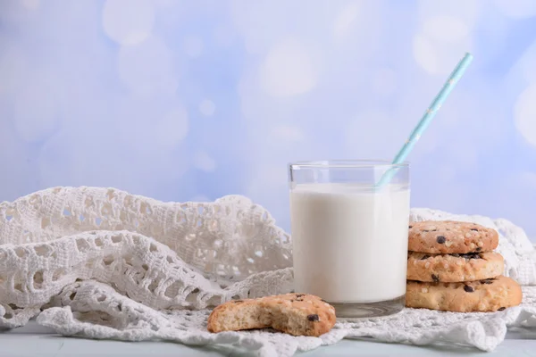 Tasty cookies and glass of milk on color wooden table, on bright background — Stock Photo, Image