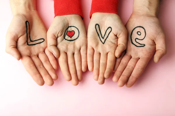 Mãos de casal com inscrição Amor, close-up view — Fotografia de Stock