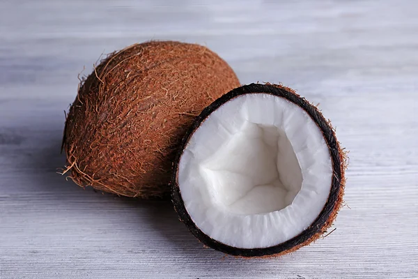 Kokosnöt skuren i hälften på träbord färgbakgrund — Stockfoto