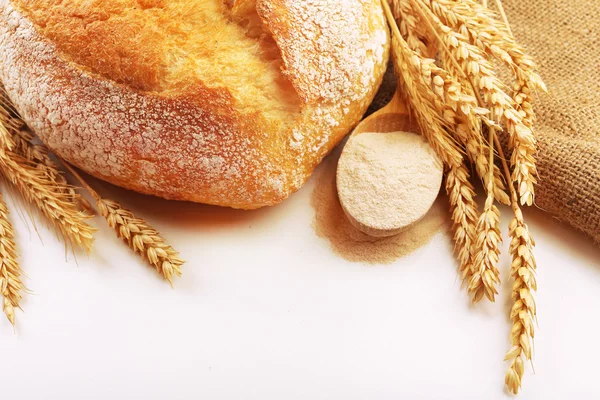 Fresh bread with wheat and wooden spoon of flour isolated on white — Stock Photo, Image