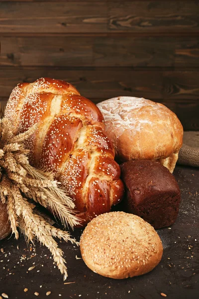 Ahşap arka plan üzerinde kulakları ile farklı ekmek — Stok fotoğraf