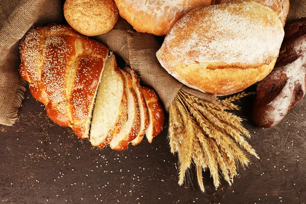 Различные хлеба с ушами на деревянном фоне — стоковое фото