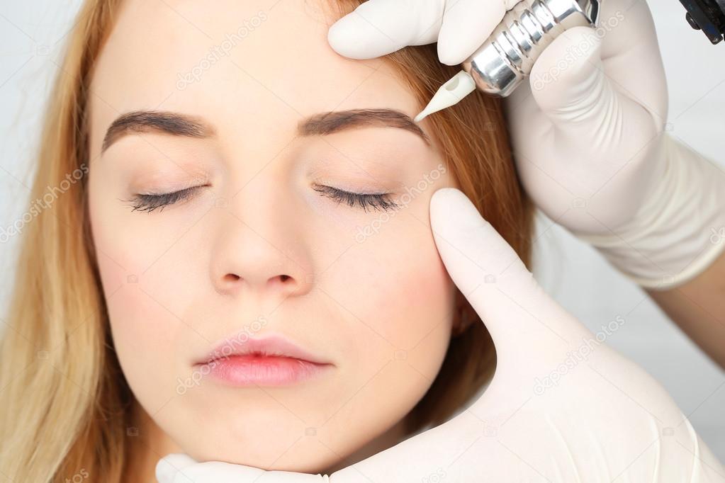 Cosmetologist making permanent makeup, close up