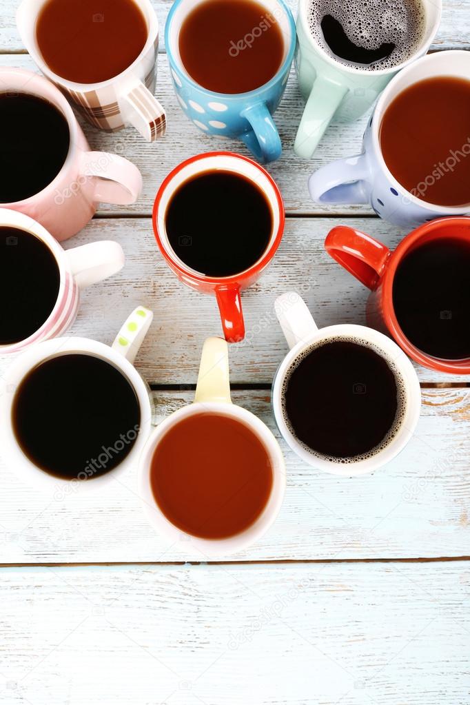 Many cups of coffee on wooden background